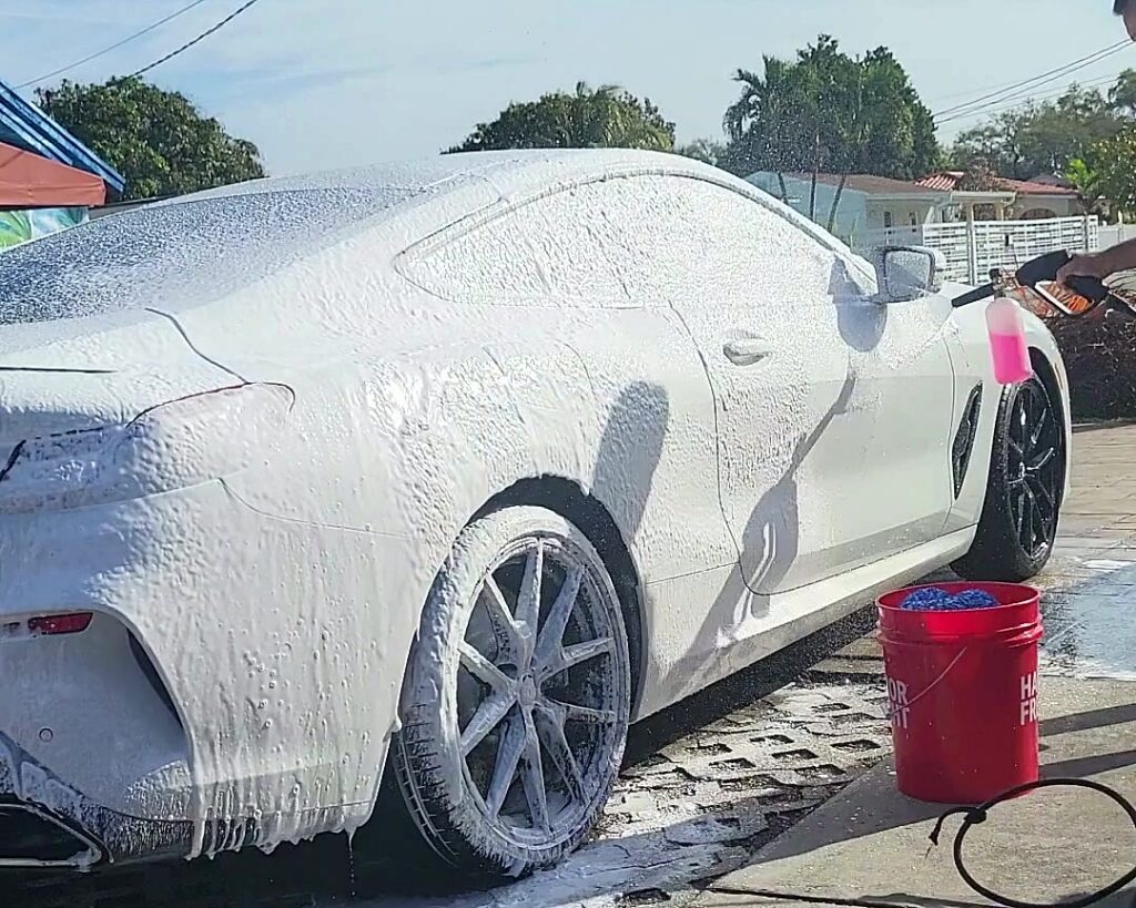 White car covered in foam during a mobile hand wash